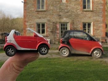 a smart car with a model smart car next to it